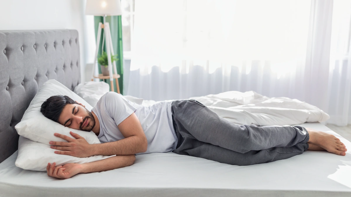 persona durmiendo de lado con almohada alineando cuello y columna