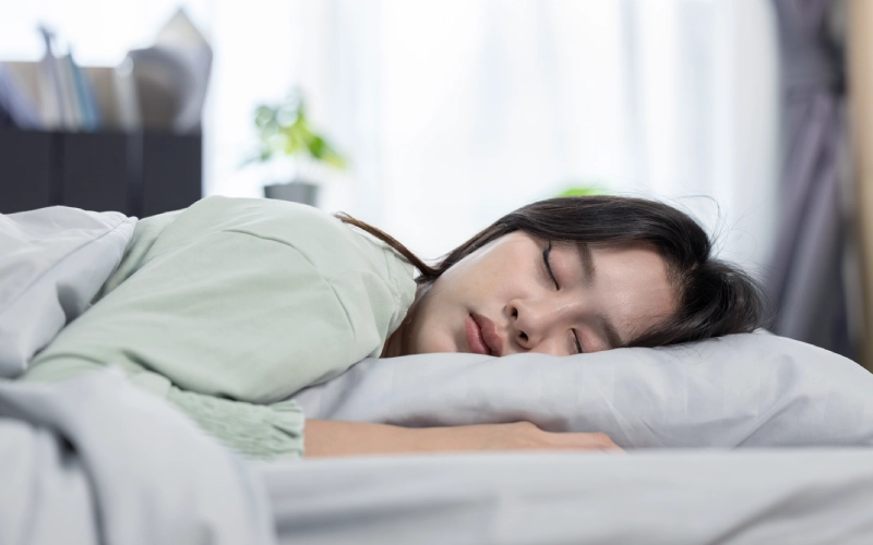 persona durmiendo boca abajo con almohada baja y cuello relajado