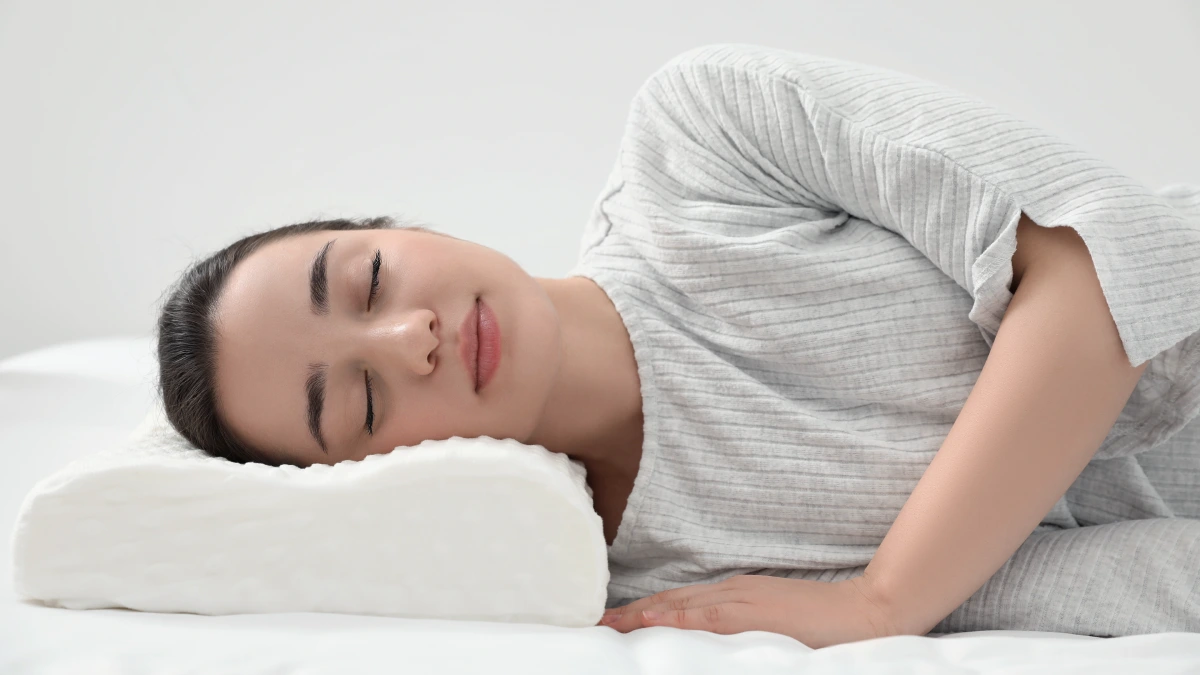 persona durmiendo de lado con almohada adecuada y correcta alineacion del cuello