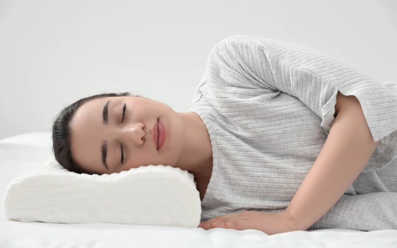 persona durmiendo de lado con almohada adecuada y correcta alineacion del cuello