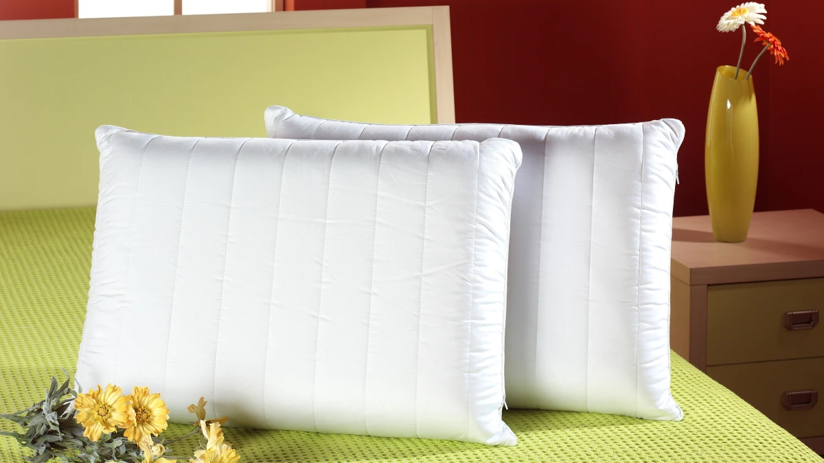2 almohadas de fibra sobre una cama