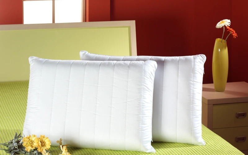 2 almohadas de fibra sobre una cama